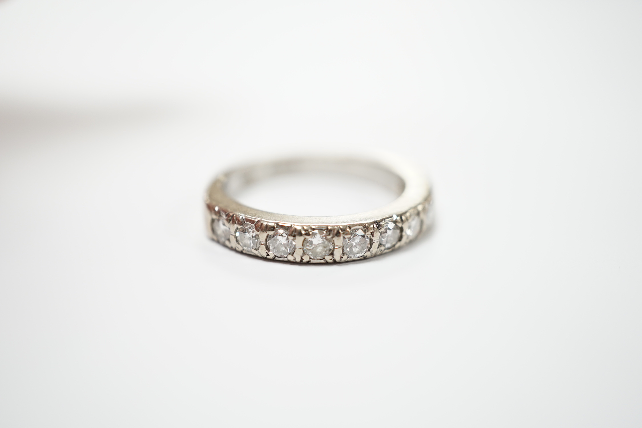 A modern 18ct white gold and nine stone diamond set half eternity ring, size M, gross weight 5.3 grams.